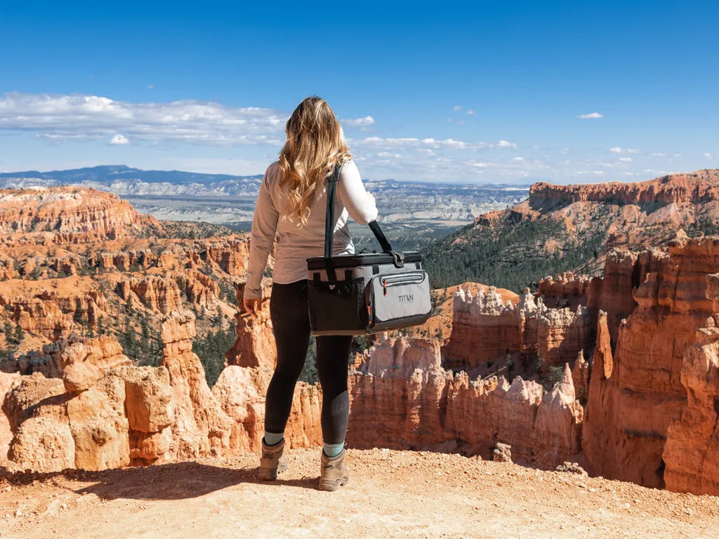 Woman carrying a Titan Zipperless Cooler while exploring a national park