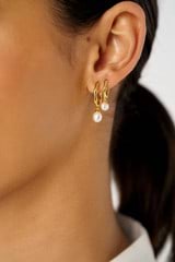 Profile view of model wearing the Oroton Melody Single Pearl Huggies in 18K Gold and Recycled 925 Sterling Silver for Women