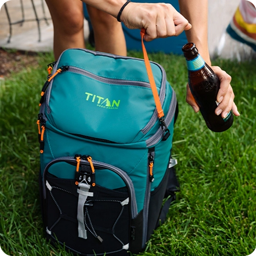 Person using a bottle opener attached to their Titan Backpack Cooler