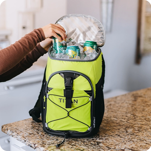 Person reaching into a Titan Backpack Cooler for an ice cold drink